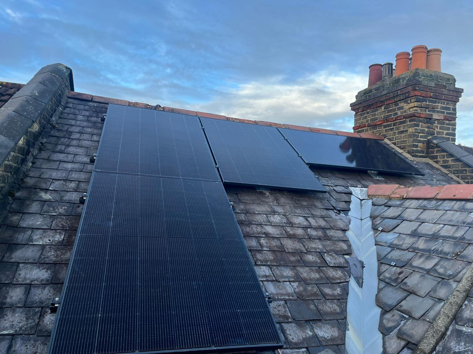 Solar PV panels installed across a slate roof — full design-and-install, sized to the household's usage.